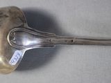 a silver spoon with a tag on it sitting on a table