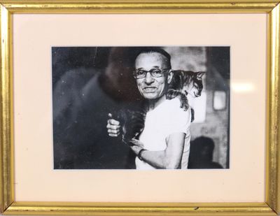 une vieille photo d'un homme tenant un chat dans ses bras