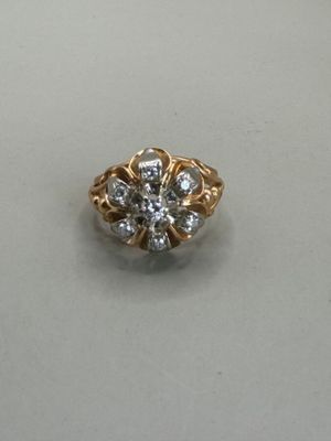 a close up of a gold and diamond ring on a white surface