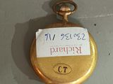 a gold pocket watch with a sign on it