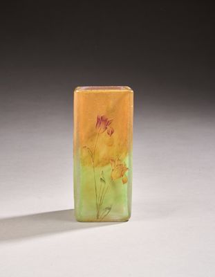 a small glass vase with flowers painted on it sitting on a table