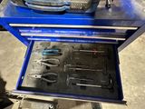 une boîte à outils bleue avec des outils sur le sol