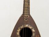un objet en forme de guitare posé sur une table, muni d'un cordon