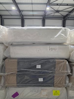 many mattresses stacked on top of each other in a warehouse