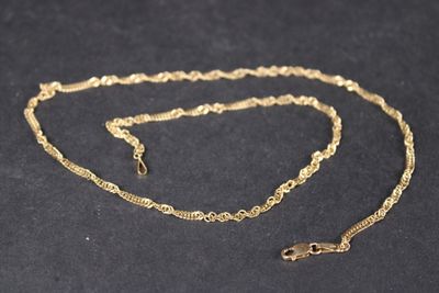 a close up of a gold chain on a black surface