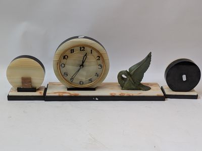 a clock with a bird figurine sitting on top of it