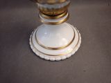 a white vase with a gold rim sitting on a table