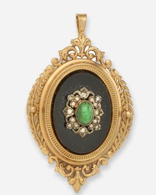 un gros plan d'une boucle d'oreille en or sertie d'une pierre verte