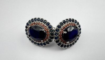 une paire de boucles d'oreilles ornées de pierres bleues et rouges