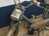 a old moped that is parked in a garage