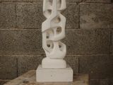 a white sculpture sitting on top of a wooden table