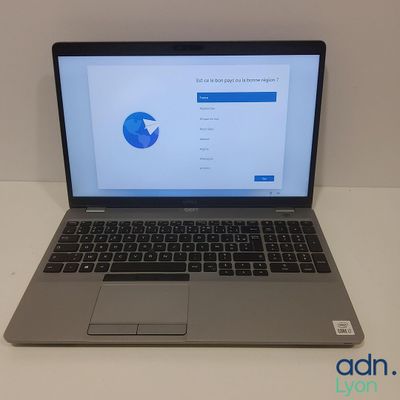 un ordinateur portable ouvert posé sur une table blanche