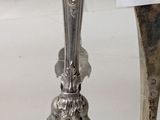 a silver spoon with a sign on it next to a silver spoon