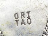 a close up of a silver plate with the word ort tao on it