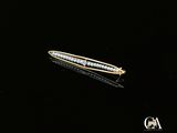 une barrette en or et diamants posée sur un fond noir