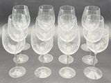 six clear wine glasses are lined up in a row