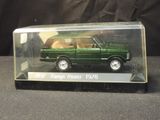 toy model of a green car in a clear box on a black surface