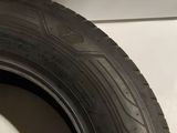 a close up of a tire on the side of a white wall