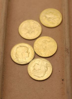 quatre types différents de pièces d'or posées sur une table