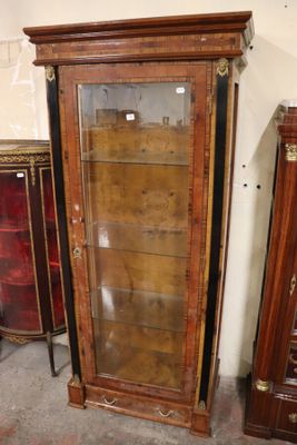 a tall wooden cabinet with glass doors in a room