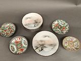 plusieurs assiettes et bols ornés de motifs asiatiques posés sur une table