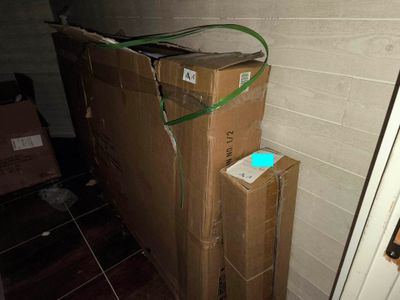des cartons empilés les uns sur les autres dans une pièce, près d'une porte