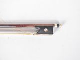 a violin bow and a bow rest on a white surface