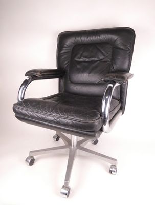 fauteuil de bureau en cuir noir avec accoudoirs chromés et repose-pieds