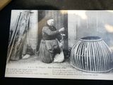 an old photo of a woman sitting in front of a basket