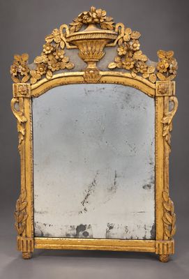 un miroir richement sculpté, avec un cadre doré sur fond gris