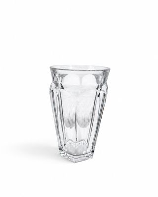 une image représentant un verre d'eau posé sur une surface blanche