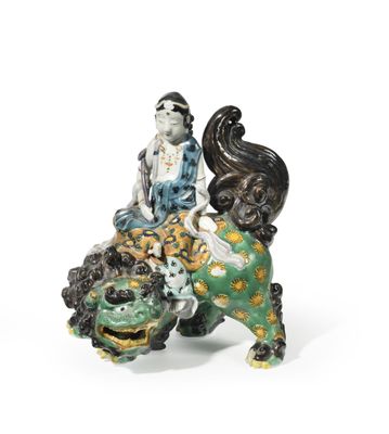 a figurine of a woman sitting on top of a lion