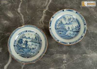 une paire d'assiettes bleues et blanches ornées d'un paysage