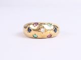 a close up of a gold ring with multi colored stones
