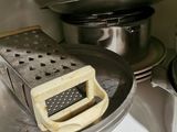 a grater and a pan sitting on a counter
