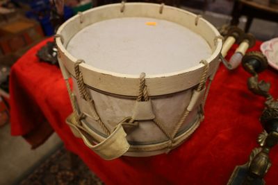 un tambour posé sur une table recouverte d'un tissu rouge