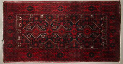 un tapis oriental orné d'un motif rouge et noir sur fond blanc