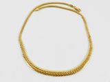 un collier en or sur fond blanc