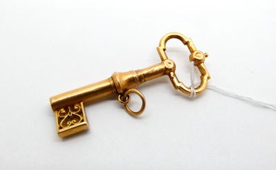 a gold key that is attached to a white string