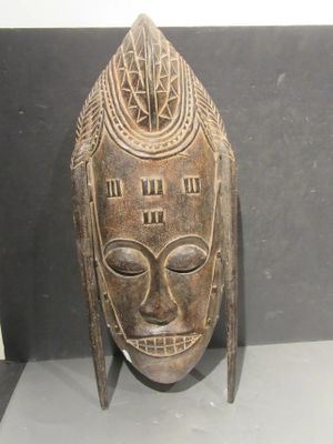 an image of a wooden mask on display in a glass case