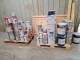 de nombreux pots de peinture posés sur des palettes dans un entrepôt