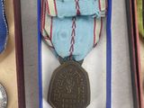 three medals and a medal are in a box on a table