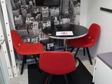 deux chaises rouges et une table noire dans une petite pièce