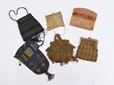 five small purses that are sitting on a white surface
