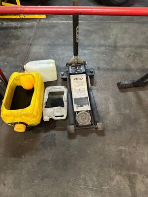 a fork lift with a yellow bucket on it and a yellow container next to it