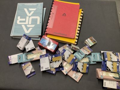 une pile de livres posée sur une table, à côté d'une pile de cigarettes