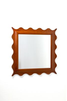 un miroir sur le mur au-dessus d'un lavabo dans une salle de bains