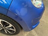 a close up of a blue car parked in a parking lot