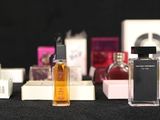 several bottles of perfume are lined up on a black surface
