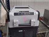 a small refrigerator sitting on a shelf in a warehouse